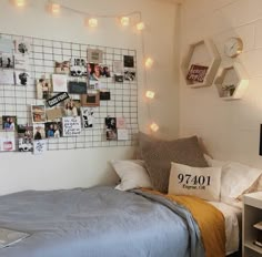 a bedroom with pictures on the wall and a laptop computer sitting on top of it