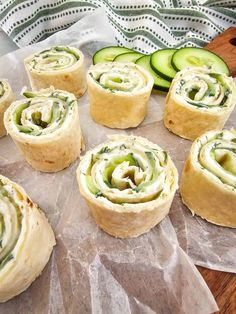 cucumber rolls are arranged on wax paper