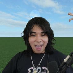 a young man holding a microphone in front of his face with an outstretched hand behind him