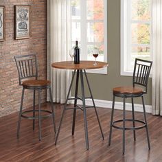 two stools and a table in front of a window with a bottle of wine on it