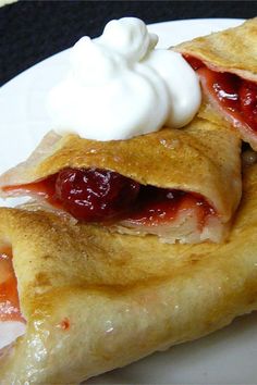 two crepes with jelly and whipped cream on top