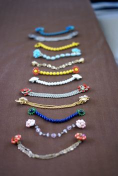 a table topped with lots of bracelets on top of a brown cloth covered table