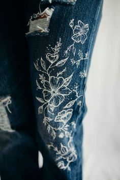 Hand painted 501 Levi Strauss jeans, featuring hand painted flowers and vines. Button closure. Machine washable, size 0 Model shown is 5'4 and a size small. Jeans With Painted Flowers, Paints On Jeans, Painted Ripped Jeans, Flower Painted Jeans, Bleach Drawing On Jeans, Painting On Jeans Aesthetic, Textile Painting Clothes, Painted Jeans Flowers, Painted Jeans Outfit