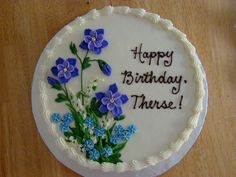 a birthday cake with blue flowers on it