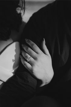 black and white photograph of a woman's hands holding her wedding ring