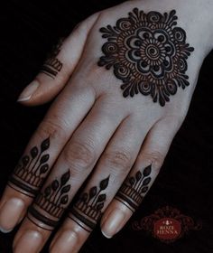 a woman's hand with henna tattoos on it