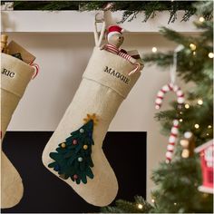 two christmas stockings hanging from a mantel