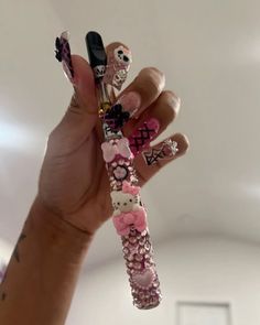 a person holding up some fake nails with skulls on them and flowers in the middle