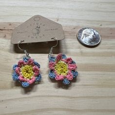 Add a touch of whimsical charm to your style with these stunning handmade earrings. Each earring features a delicate micro-crocheted flower motif, crafted with precision and care. The flowers showcase a vibrant pink and blue palette with a cheerful yellow center, creating a beautiful contrast that stands out. Lightweight and comfortable, these earrings are perfect for everyday wear or special occasions. Their unique design and intricate detailing make them a delightful addition to any jewelry collection. Whether you're dressing up or keeping it casual, these earrings will add a splash of color and a hint of playful elegance to your look. Whimsical Multicolor Flower Charm Earrings, Everyday Multicolor Handmade Earrings, Handmade Cute Flower Drop Earrings, Cute Handmade Drop Flower Earrings, Handmade Whimsical Dangle Flower Earrings, Everyday Bohemian Dangle Flower Earrings, Cute Handmade Dangle Flower Earrings, Handmade Everyday Flower Drop Earrings, Handmade Dangle Flower Earrings