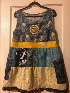 This is a one-of-kind handmade short patchwork dress. The fabric is 100% cotton, prewashed; blues and yellows. Jasper Sun patch and 2 side pockets. Fits women's M