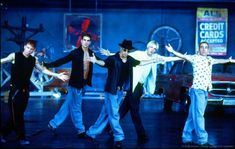 the cast of grease dancing on stage