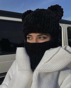 a woman wearing a black bear hat and scarf