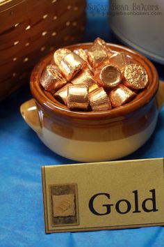 a wooden bowl filled with gold next to a sign