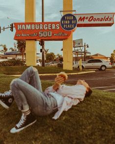 a man laying on the ground in front of a mcdonald's