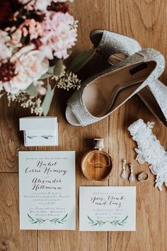 the wedding suite is laid out on the floor with shoes, rings and bouquets