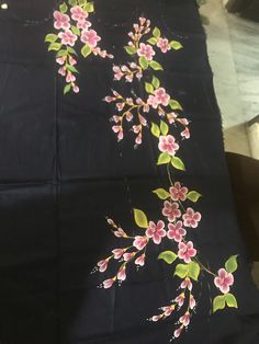 a black cloth with pink flowers painted on it