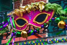 a mardi gras mask hanging from the side of a building