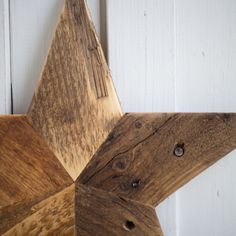 a wooden star hanging from the side of a white door with wood grains on it