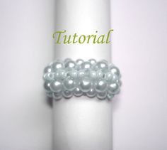 a ring made out of pearls sitting on top of a white tablecloth with the words,'tutorial'written above it