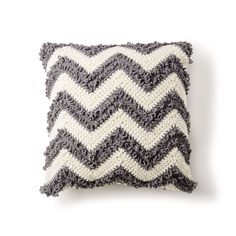 a gray and white crocheted pillow on a white background with the words, chevron