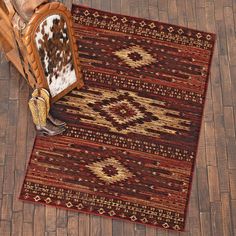 a brown and white rug sitting on top of a wooden floor next to a chair