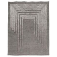 an area rug with grey squares on the floor and one square in the middle, surrounded by