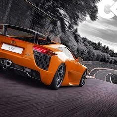 an orange sports car driving down a winding road