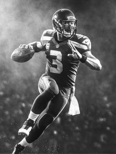 a black and white photo of a football player running with the ball in his hand