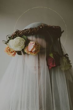 a woman wearing a veil with flowers on her head