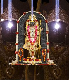 an idol is displayed in front of some lamps and lights on the wall behind it