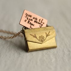 This charming personalised locket is shaped like a tiny envelope with a working clasp, and fitted inside is a tiny surprise message! Your message will be beautifully engraved on a solid copper letter in our Edinburgh studio, and can be personalised either in your own handwriting or a beautiful vintage copperplate script. Both options are shown in our photos. HOW TO SUBMIT HANDWRITING FOR LOCKET Once you have purchased the locket, please go ahead and message us with an photo of your handwritten m Vintage Necklace With Engraving Option As Gift, Personalized Brass Necklaces For Mother's Day, Personalized Brass Locket Necklace For Gift, Mother's Day Engraved Brass Necklaces, Mother's Day Engraved Brass Necklace, Envelope Shaped Necklace For Mother's Day Gift, Stamped Brass Charm Necklaces As Gift, Mother's Day Gift Locket Necklace With Engraving Option, Personalized Vintage Charm Necklaces As Gift