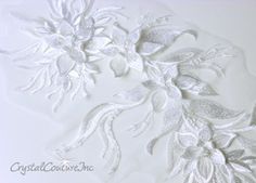 an intricately designed white paper with flowers and leaves in the center, on a white background