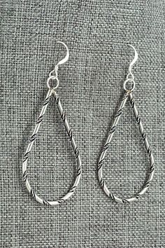 These sterling silver earrings were made by Navajo silversmith Nashina Leonard.Length: 2 1/4"Width: 1"Free shipping on all orders! We ship with USPS and always include tracking. All orders ship within a day of payment.Returns are accepted up to 30 days after you receive your order. Just send us a message. Our shop offers cash back or store credit. The item must be returned in new condition. Nickel Free Silver Southwestern Earrings, Artisan Sterling Silver Nickel-free Teardrop Earrings, Traditional Nickel-free Sterling Silver Teardrop Earrings, Silver Southwestern Style Teardrop Dangle Earrings, Southwestern Silver Dangle Teardrop Earrings, Handmade Southwestern Sterling Silver Earrings, Silver Southwestern Style Earrings For Gifting, Silver Southwestern Dangle Jewelry, Silver Southwestern Earrings For Gift