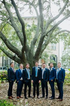 a group of men standing next to each other under a tree