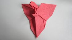 an origami bird made out of pink paper