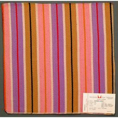 an orange, pink and purple striped blanket with a white tag on the bottom of it