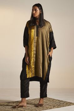 Black, gold colorblock kaftan tunic with stripe pattern. Paired with pant.
Component: 2
Type Of Work: Stripe
Neckline: V neck
Sleeve Type: Three quarter
Fabric: Handwoven Pure Silk, Cotton Silk
Color: Black,Gold
Other Details: 
Approximate Product Weight (in kg): 1
Side pockets
Note:
Dupatta worn by the model is not for sale
Since all our products are sustainable and touched by human hands for weaving, block printing and embroidery; there might be a slight imperfections that make them unique and Kaftan Tunic, Black Kaftan, Kaftan Designs, Short Kaftan, Silk Kaftan, Human Hands, Dream Wedding Ideas Dresses, Silk Tunic, Indian Fashion Dresses