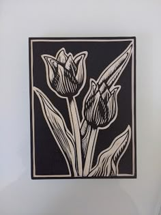 a black and white drawing of tulips in a square frame on a wall