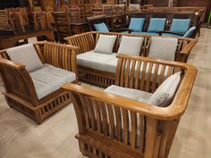 a room filled with lots of wooden furniture and blue cushions on top of each chair