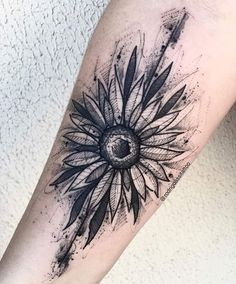 a black and white tattoo with a sunflower on the arm, done in ink