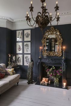 the room is decorated in blue and gold with candles on the fireplace mantels