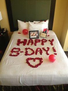 a bed with flowers and balloons on it that says happy new year's eve