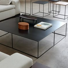 a living room filled with furniture and a book on top of a black coffee table