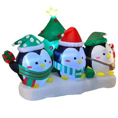 an inflatable penguin family with christmas hats and scarfs