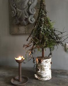 a small christmas tree sitting next to a lit candle