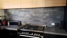 a stove top oven sitting inside of a kitchen next to a microwave and toaster