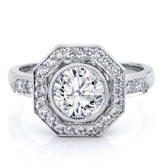 an engagement ring with diamonds on the sides and a center stone surrounded by smaller round stones