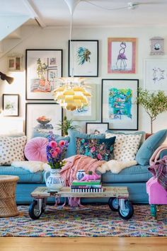 a living room filled with lots of furniture and pictures on the wall above it's couch