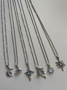 These  beautiful necklaces are hand made with a 48cm stainless steel chain. On the chain, hangs a stunning silver plated, iridescent, blue pendant with various unique designs to choose from! It is perfect for daily wear or as a gift to a friend or a loved one!   Styles  ☆ Crescent ☆ Celeste   ☆ Aurora   ☆ Ceres  ☆ Seren    ☆ Flare !! These pendants have a unique blue colour that changes with different angles and lighting !! ♡ The chain is stainless steel and is approximately 19 inches in length. Silver Crystal Pendant Necklace With Charms, Silver Celestial Nickel-free Charm Necklaces, Silver Metal Crystal Necklace With Lobster Clasp, Silver Celestial Crystal Necklaces For Jewelry Making, Celestial Silver Crystal Necklaces For Jewelry Making, Silver Pendant Crystal Necklace With Lobster Clasp, Silver Crystal Pendant Necklace With Clavicle Chain, Silver Pendant Crystal Necklace With Clavicle Chain, Handmade Silver Celestial Charm Necklace