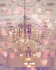 a chandelier hanging from the ceiling in a room with many hearts on it